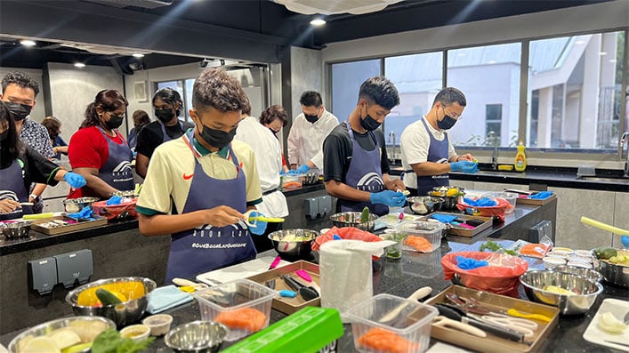 Minister-in-Charge of Social Services Integration Desmond Lee (first from right) and PPHG Executive Director (Sustainability Partnerships, Lifestyle & Asset) Wee Wei Ling (fourth from right), joined a culinary class with ComLink+ youths, conducted by PPHG chefs.